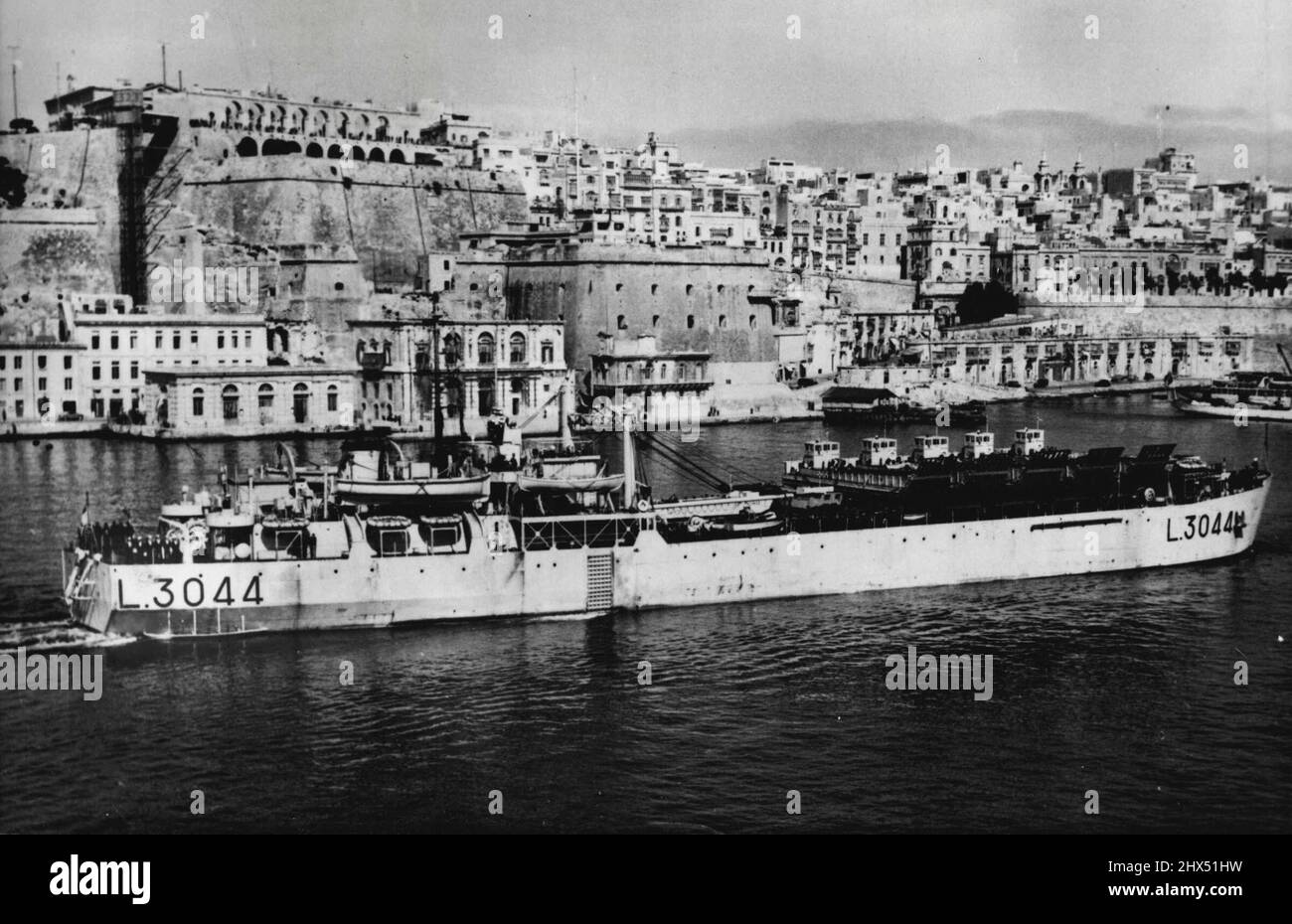 Atomic Equipment For Woomera -- The royal navy tank landing craft 'Narvik' sails out of grand harbour, Malta, recently on her voyage to Australia. She, and the 'Zeebrugge,' another tank landing craft, are en route from Portsmouth, England, loaded with atomic equipment for the Woomera rocket range, the site of Britain's forthcoming atomic explosion. Among the gear carried is armour-plated cable, portable electric power station and assault craft. March 8, 1952. (Photo by Associated Press Photo). Stock Photo