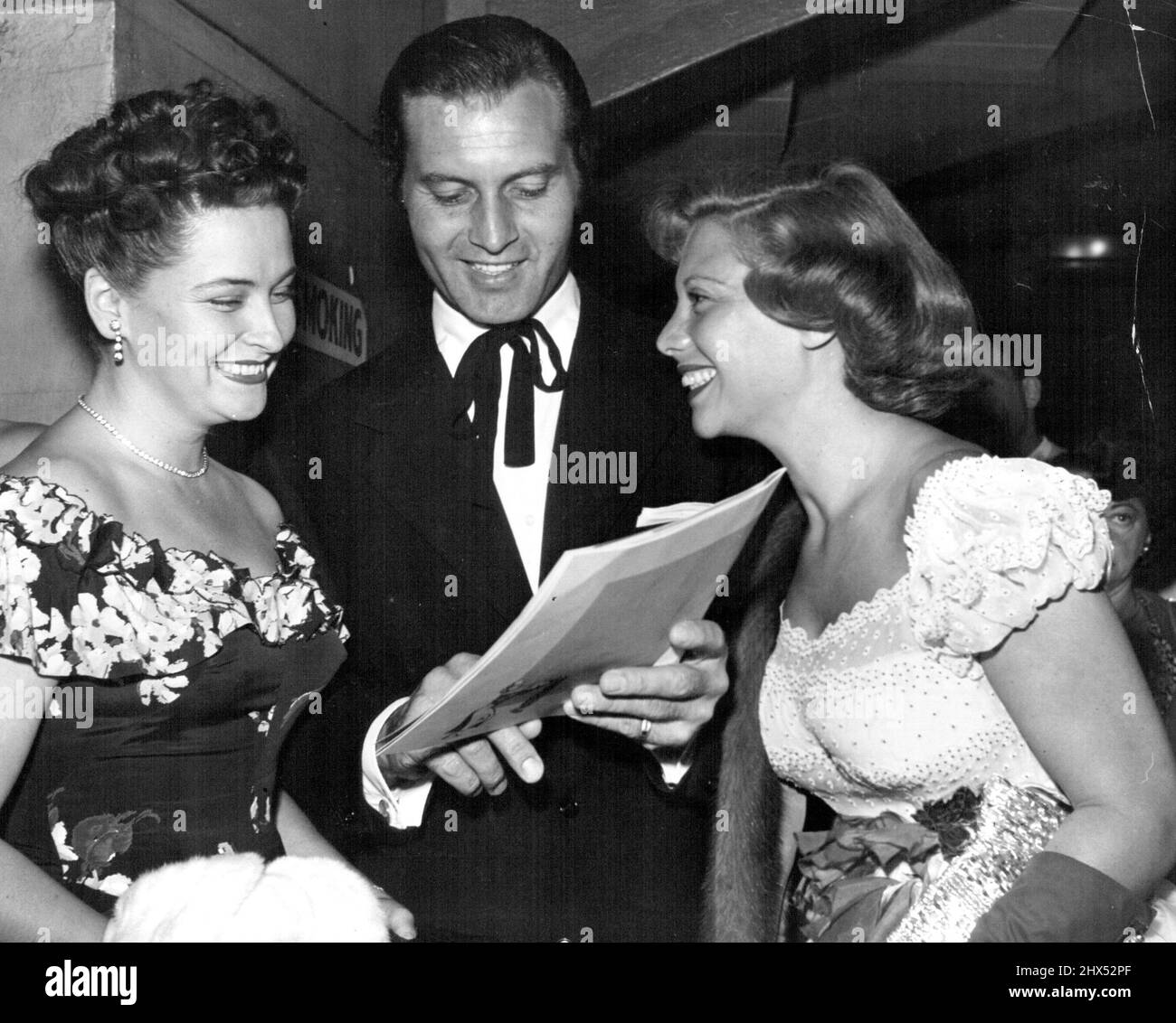 Mrs. John Raitl with George Montgomery and his wife, songstress Dinah Shore, at the opening in Los Angeles of a musical called Magdalena. Mrs. R's husband was the star. That tie must be an old Southern custom. October 27, 1948. Stock Photo