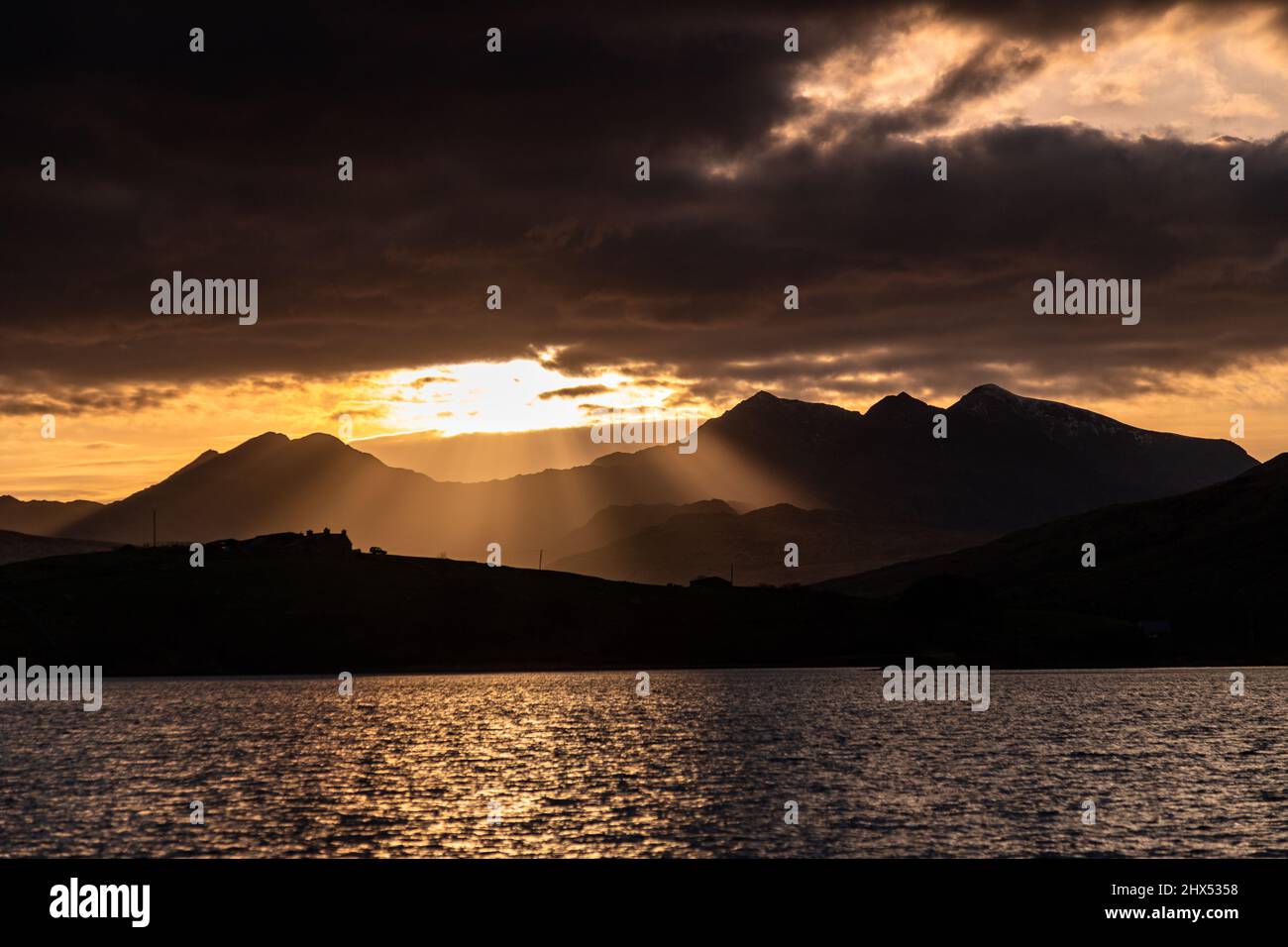 Snowdon mountain with sunbeams at sunset, Snowdonia, North Wales Stock Photo