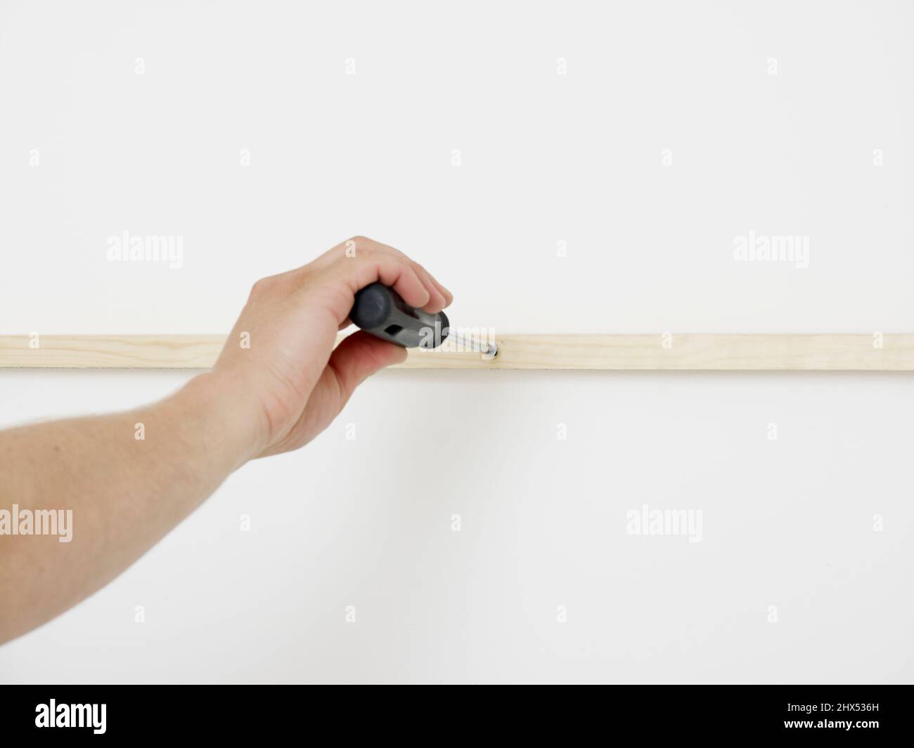 Building and fitting alcove shelves, screwing the batten to the wall