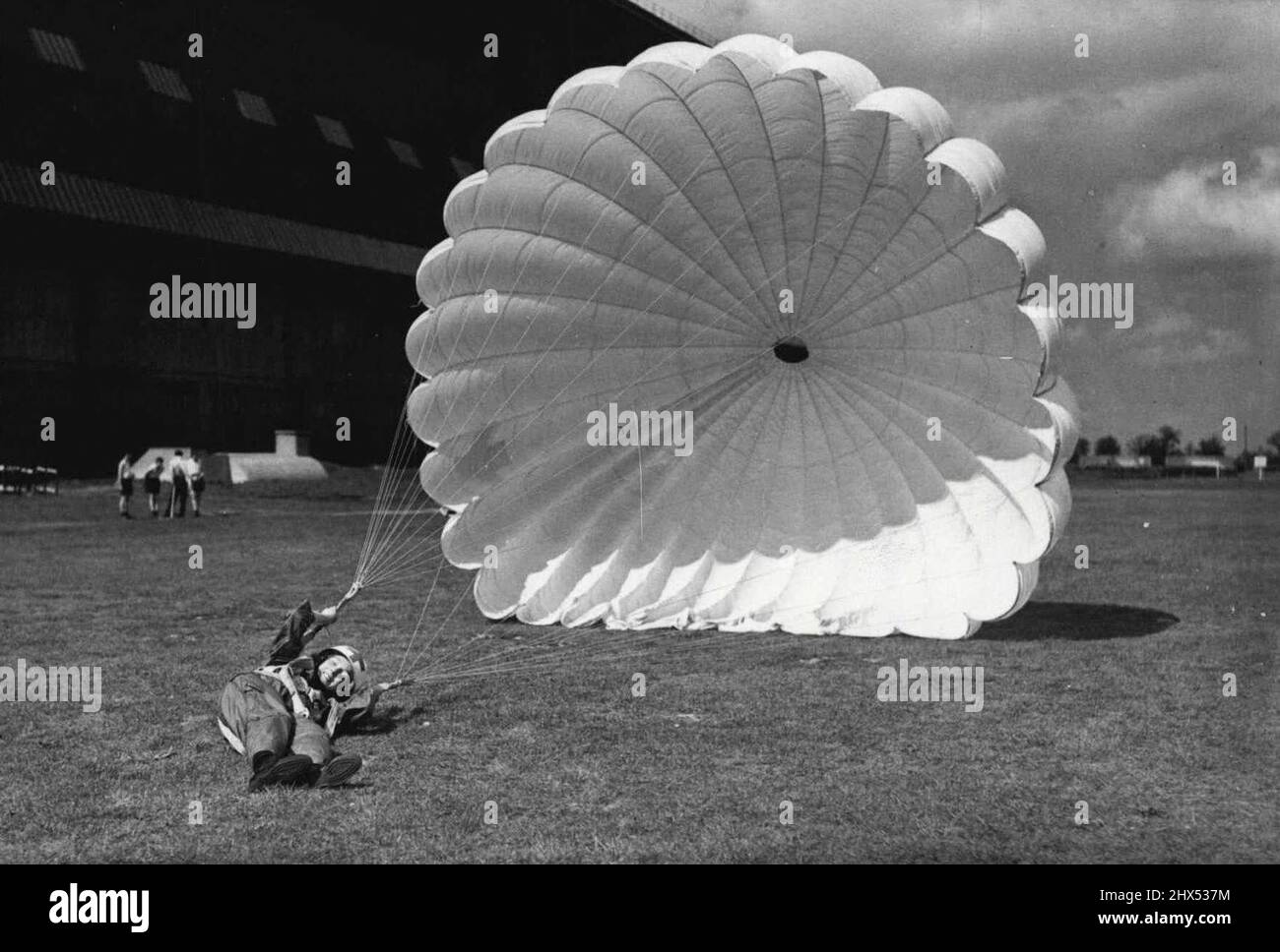 Britain's Parachute Nurses Rehearse for the Royal Tournament - Aircraftman G. Sheldon gets caught in the breeze and is dragged by her parachute after making a desert during rehearsal at Cardington. Teams form all branches of the Services are ***** hard at work rehearsing for the forth coming Royal Tournament to be opened at Earls Court, London. A feature of the Tournament will be a display by parachute nurses of the R.A.F. Nursing Orderly Services. May 19, 1950. (Photo by Sport & General Press Agency, Limited). Stock Photo