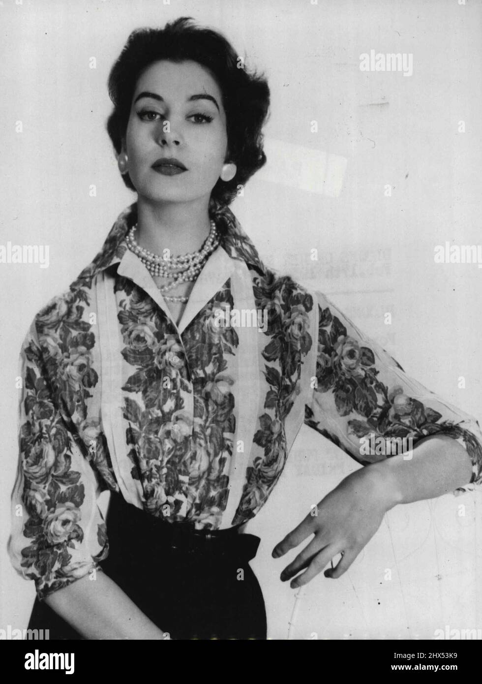 Blooms On Her Blouse -- For summer smartness is offered this shirt-blouse in Sudan cotton, featuring flower-stripes. Named ' Ann Hathaway ' by its designer, Digby Morton, it should be just the thing ' for those warm June days - that we sometimes get!. February 17, 1955. (Photo by Reuterphoto). Stock Photo
