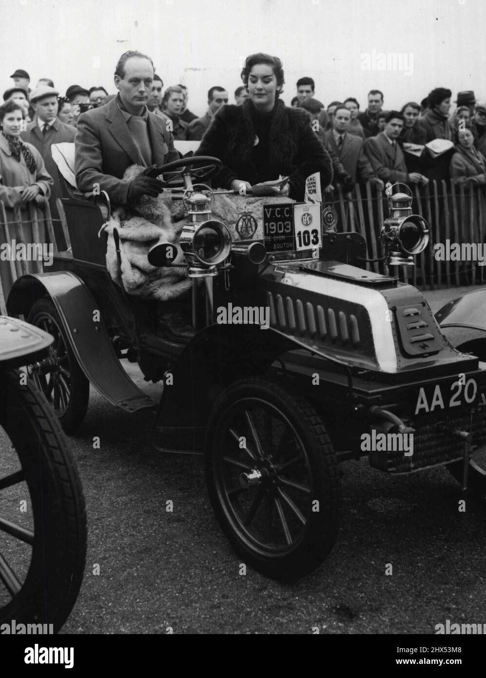 Veteran British Jalopies In London-Brighton 'Run' -- Lord Montague in his 1903 De Dion Bouton two seater after he arrived in Brighton. With him is Mrs. E.G.Wyndham.Despite rumours to the contrary, the British are a very sentimental people. First on their list of affections come animals, second -- a very close second -- ancient automobiles. Old crock worship reaches its zenith each year with the annual run between London and the seaside resort of Brighton, some 50 miles a way. Some 150 grandpa's chariots competed this year in the run, held last Sunday, and most of them made it. Some only took t Stock Photo