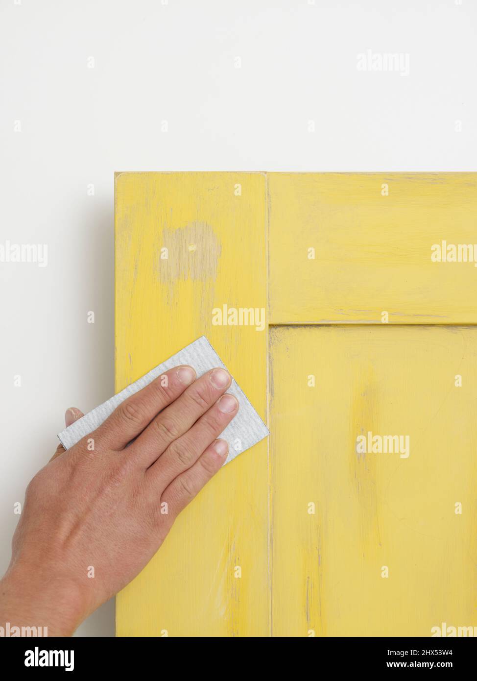 Repainting a kitchen unit, sanding down a door Stock Photo Alamy