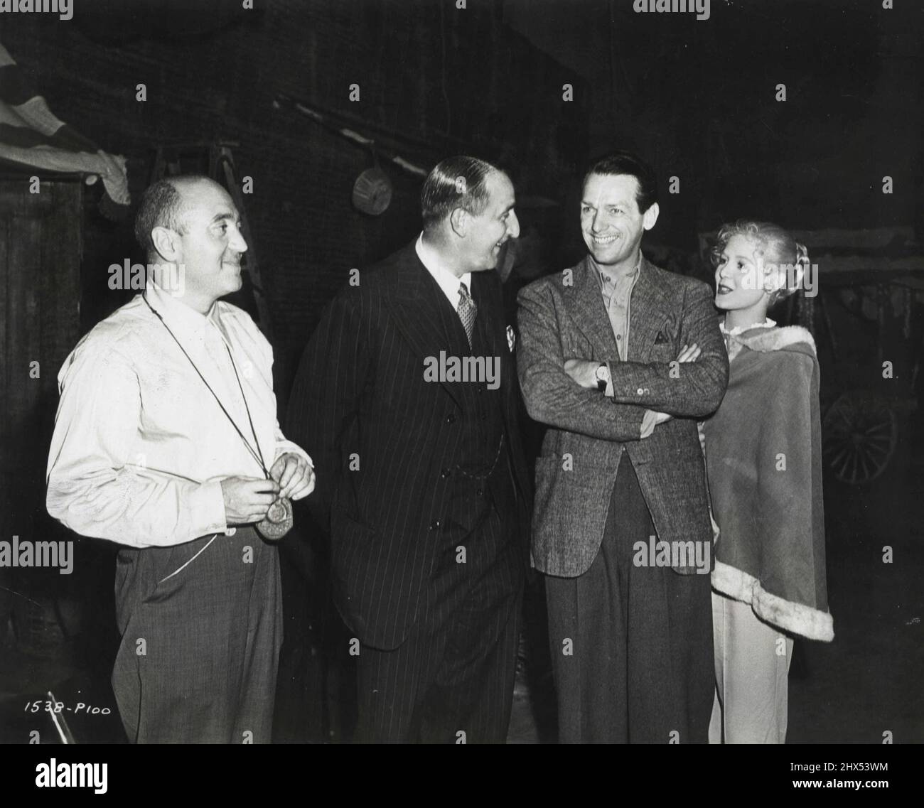 International relations get a healthy pickup when British film magnate, J. Arthur Rank (second from left) visits Douglas Fairbanks on the set of 'The Exile' at Universal-International and meets Doug's new discovery, Paule Croset (right), who is Swiss, and Director Max Ophuls, who was French before coming to this country. December 23, 1947. (Photo by Universal-International). Stock Photo