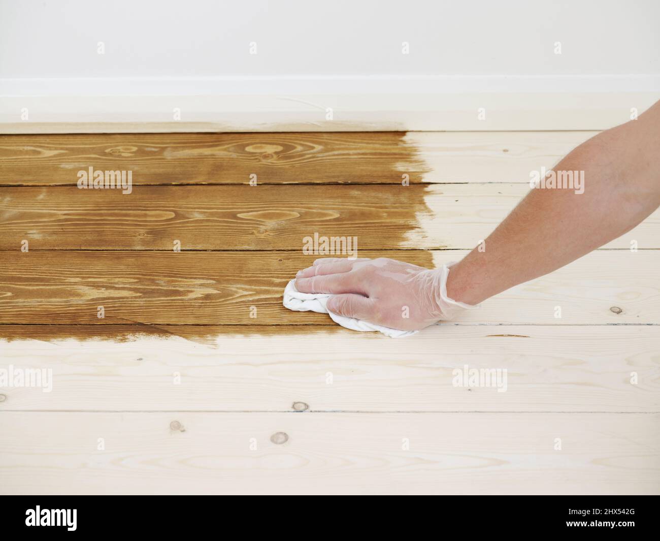 Staining a wooden floor, applying the stain with a cloth, working in