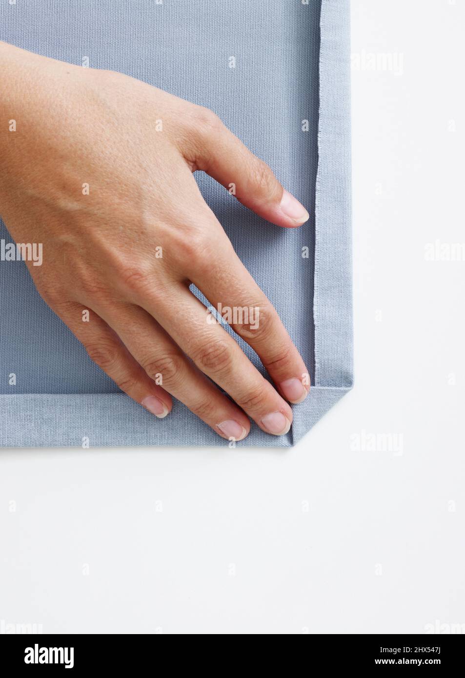 Folding over corner at edge of pale blue upholstery fabric Stock Photo