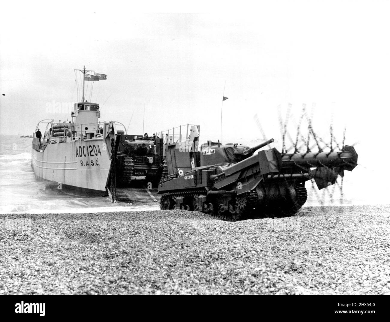 Tanks And Troops Storm South Coast Beaches In Amphibious 'Invasion'.Today in operation Runaground III, 'enemy' forces, consisting of men of the Gloucesters, Royal Marine Commandos, and Hussars with Centurion, Sherman and Caurchlli tanks,stormed the beach at Eastney, near Portsmouth is the biggest combined amphibious exercise since the war. Frognen dropped from a plane led the way, arid support was given to the landing from RAP and; Navy aircraft Helicopters were used for the first time in a landing and the Royal Engineers provided an impressive display of flashes and bangs for atmosphere.Tanks Stock Photo