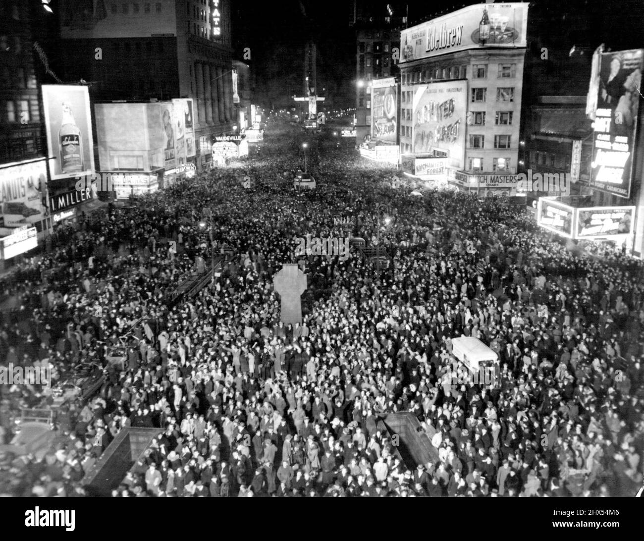 Times Square Throng Hails New Year. This Picture of Jam-Packed Times Square in New York was made exactly at Midnight Dec.31 as New Yorkers Thronged the 'White Way' to welcome 1946. The view is from 47th street and Broadway, looking south. January 1, 1946. (Photo by Associated Press Photo). Stock Photo