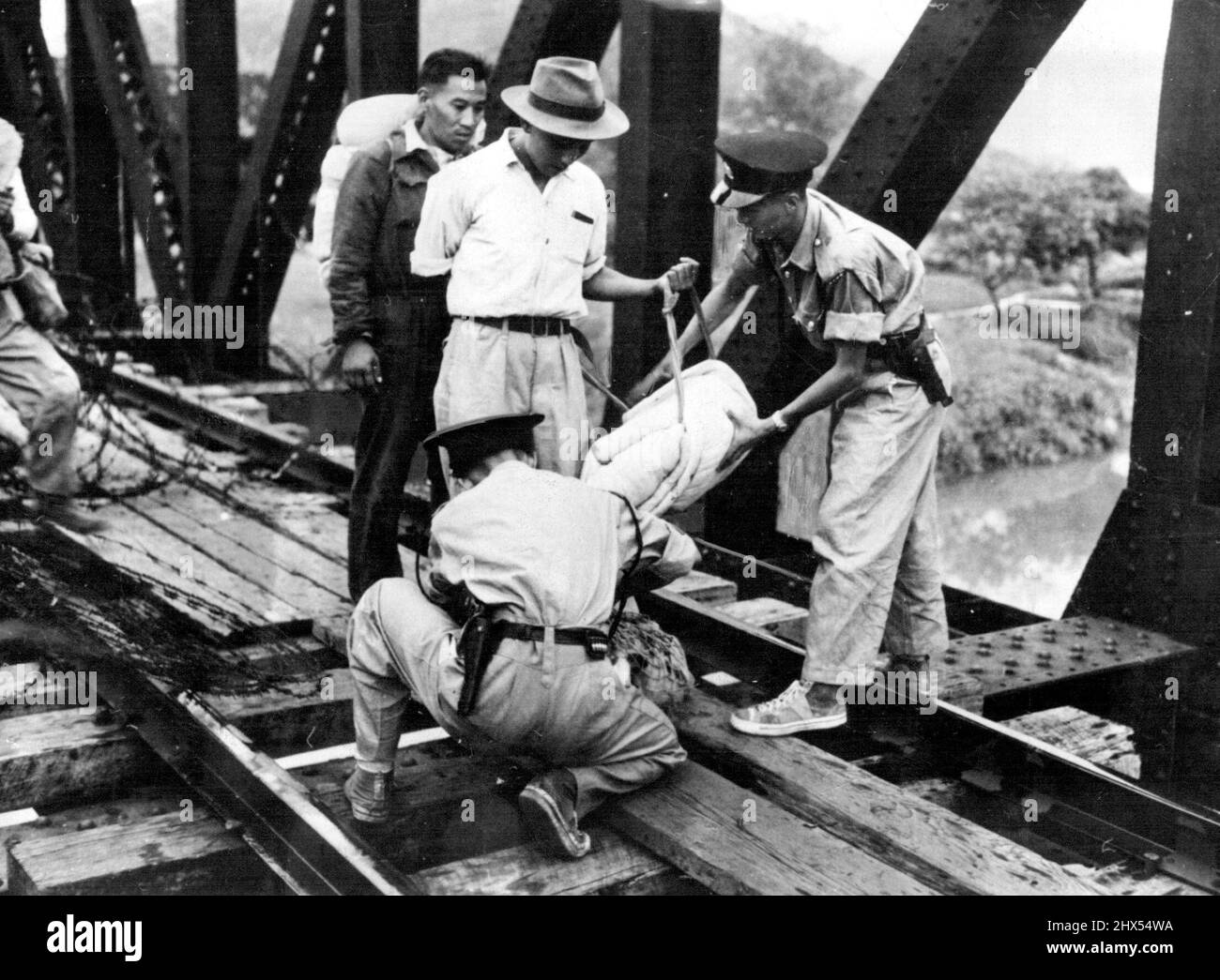 Border Precaustions - In *****. Two constables if the Hong Kong police examine parcels of personal goods belonging to Chinese on their way across the border into the British territory. At the railroad bridge of Lou, which marks the frontier between Chinese and British territories, Chinese making their way into the British zone have their bundles searched for small arms by two Chinese constables of the Hong Kong Police, in this picture just received from Hong Kong. October 27, 1949. (Photo by Reuterphoto). Stock Photo