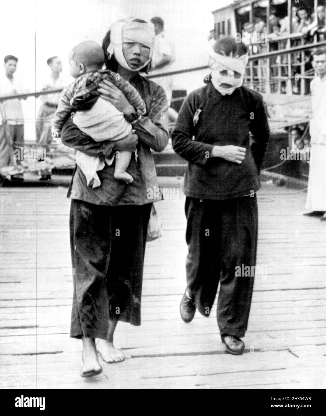 Victims Of Chinese Naval Warfare -- Two of the walking wounded from the British coastal steamer Cheung Hing--both Chinese women--walk ashore at Hong Kong. Ship's captain said Chinese Nationalist warship shelled the Cheung Hing June 5 off Amoy. Eight were killed. June 10, 1950. (Photo by AP Wirephoto). Stock Photo