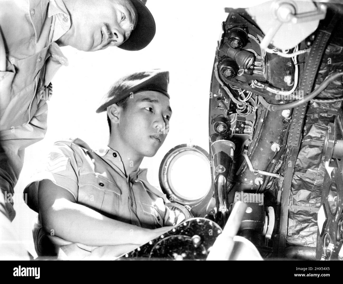 Pre-Look For Cadet. Flight Lieut. G. C. Turnbridge, No. 2 RAAF Squadron at amberley, shows Chinese Cadet Raymond Lam, who is nothing Australia with the Federation of Malaya. An training corps over a Canberra jet former Canberra will go into operation in Malaya next month. January 14, 1955. Stock Photo