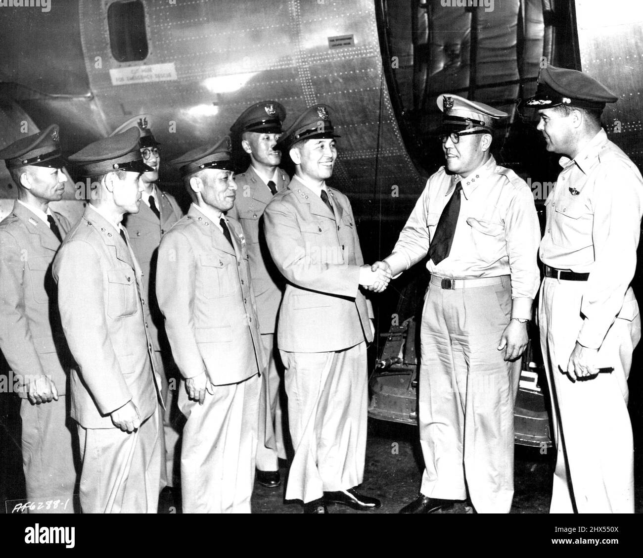 Japan Air Self Defence Force Officers Depart For The United States. Col. Eugene B. Le Bailly, Chief, U. S. Air Force Section, Military Assistance Advisory Group, Japan, (right) watches Lt. Gen. Kentaro Uemura (center), Chief of Staff of the Japan Air Self Defense Force, bid farewell to Lt. Gen. Sadsmu Sanagi, Deputy Chief of Staff, and five other high-ranking Japan Air Self Defense Force officers before their departure last night from Tokyo International Airport for a three-week staff orientation visit of U. S. Air Force bases in the United States. September 17, 1954. Stock Photo