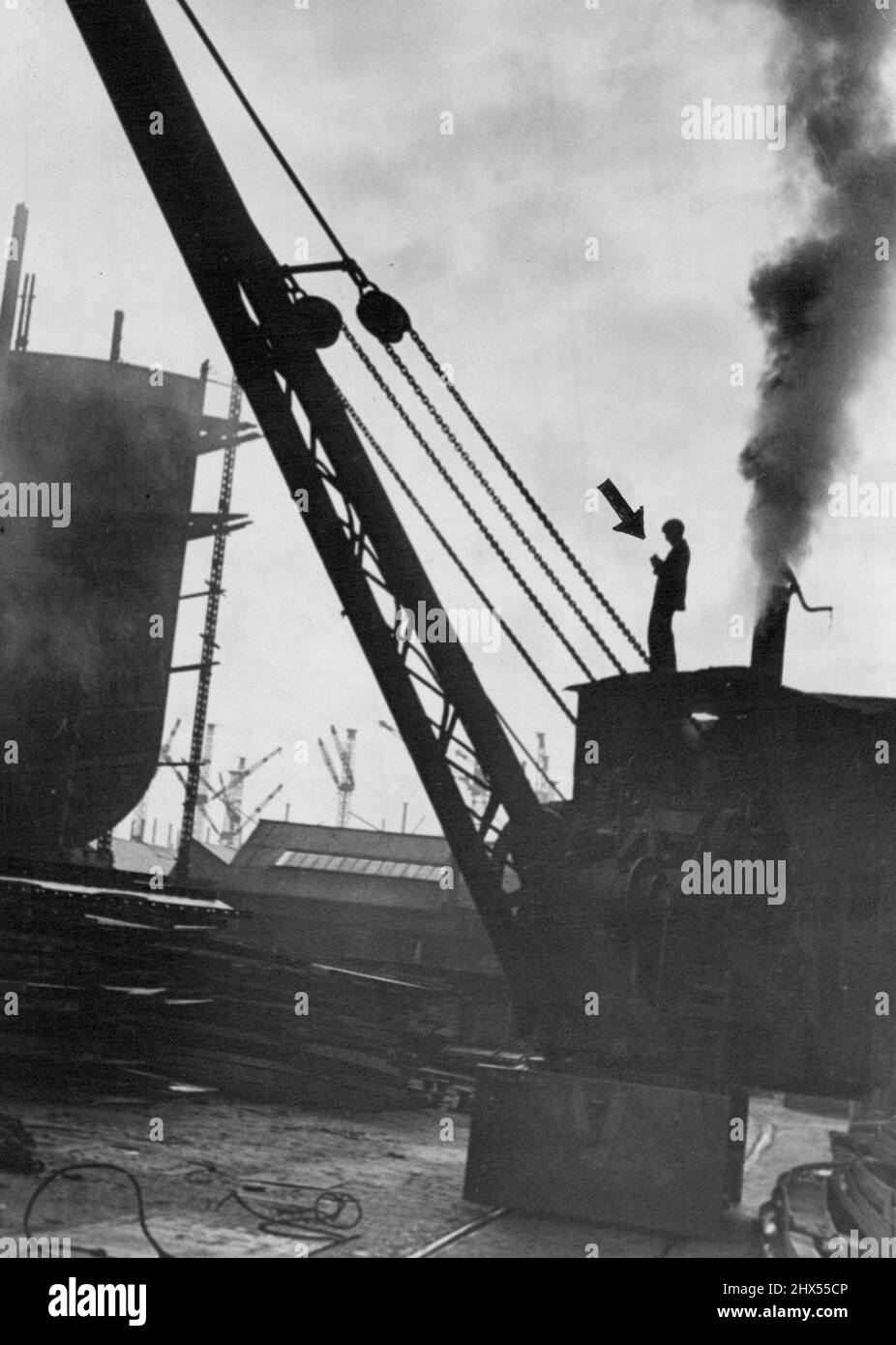 Stanley Spencer - He Stands on the Crane. From the Cabin of the giant crane he can get a different view of the pattern he has been drawing. January 29, 1944. (Photo by Paul Popper). Stock Photo