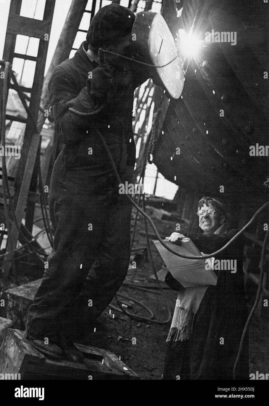 What The Artist Is Sketching: A burner prepared for welding. With the Oxy-acetylene apparatus, the burner works on the plates before the electrical wilding. Below him, the artist draws what he sees. January 29, 1944. (Photo by Paul Popper). Stock Photo