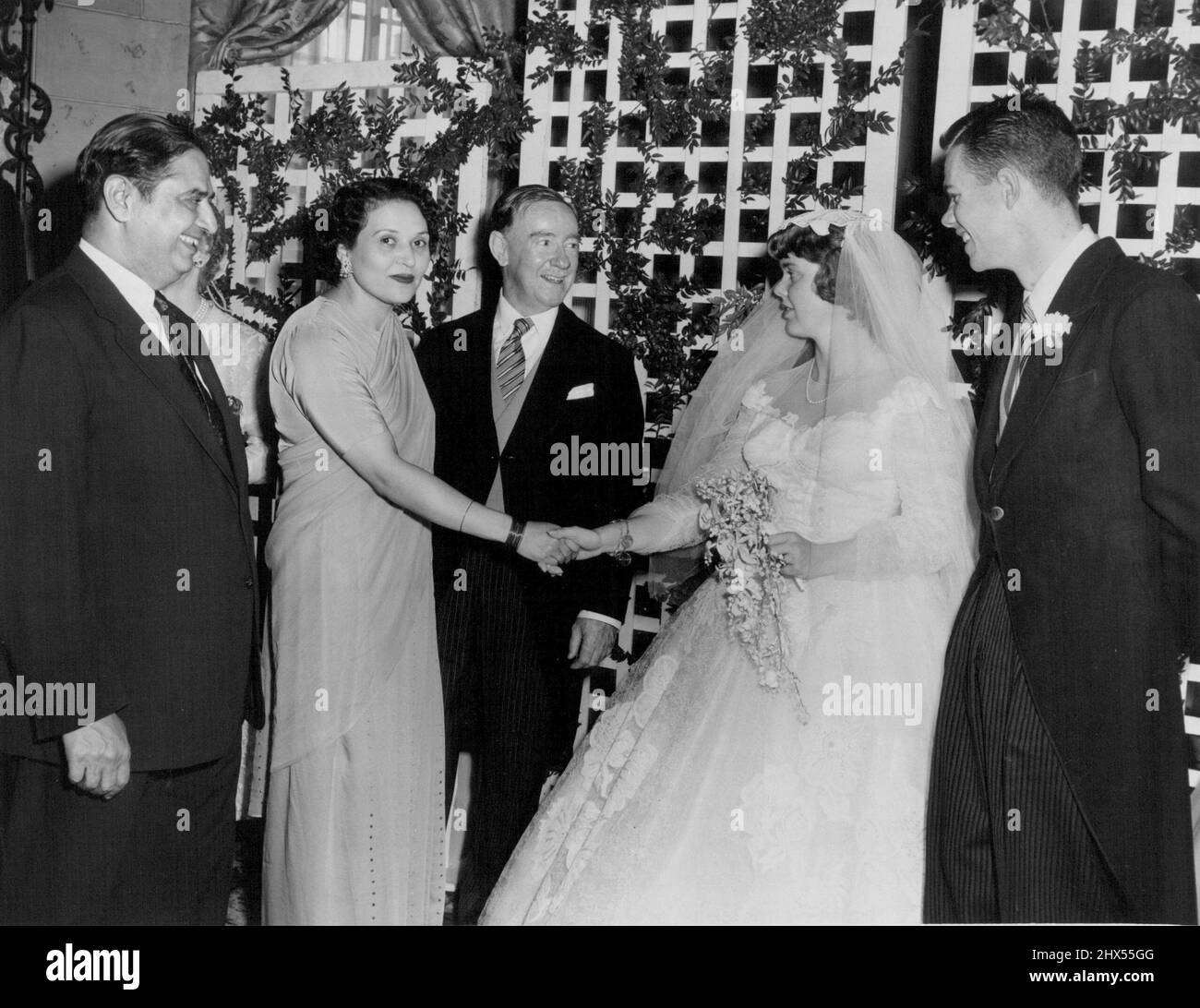 Spencer - Lynch Wedding -- Mrs. Peter Spencer greets the Ambassador of Pakistan and Begum Syed Amjad Ali at the wedding reception at the Sheraton Carlton Hotel, Washington, while Sir Percy and Peter Spencer look on. July 02, 1954. (Photo by Reni Photos). Stock Photo