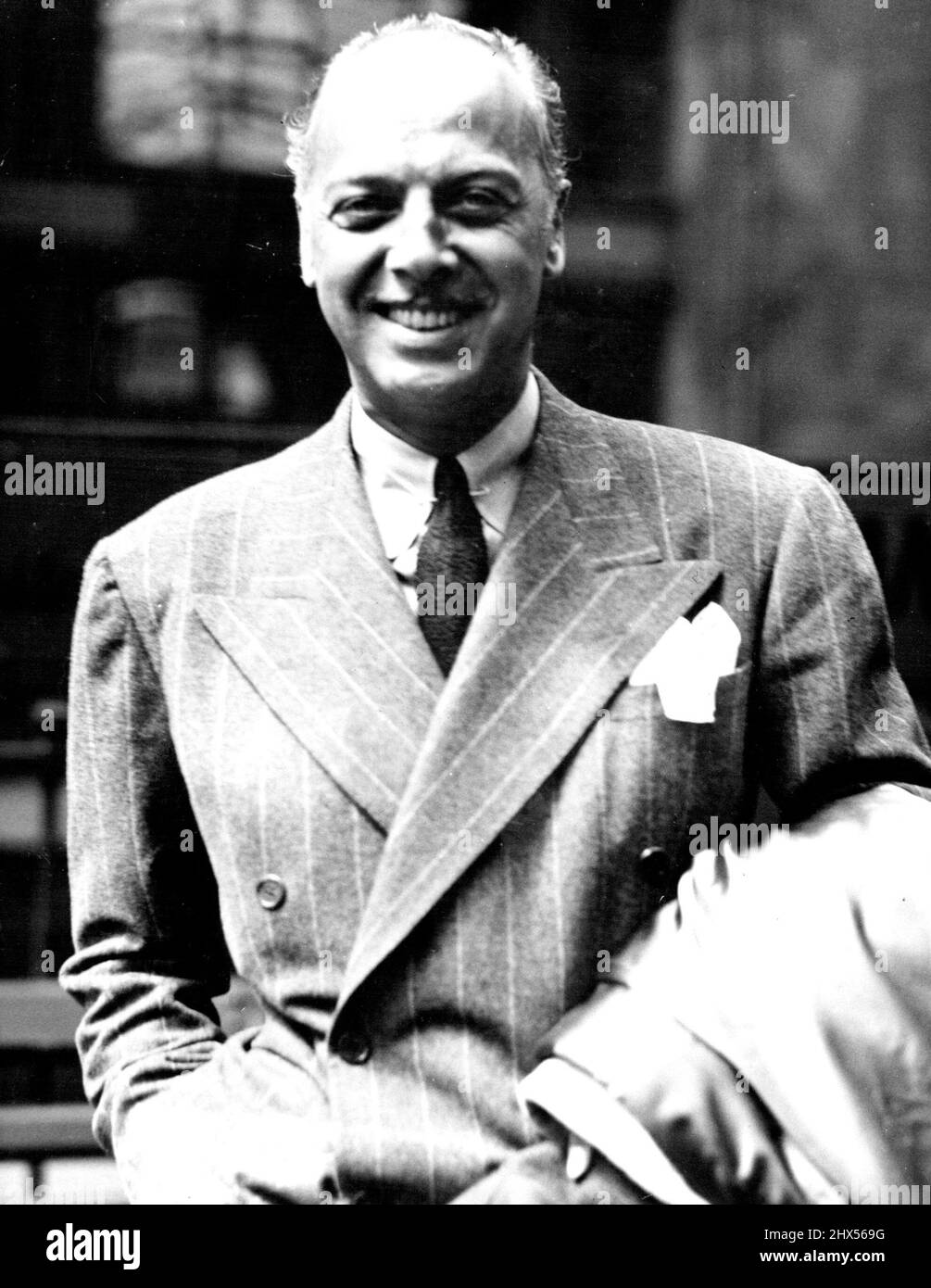 'Best Dressed' Film Director Arrives -- Mr. Mitcheel Leisen on arrival at Waterloo by the 'Normandie' boat train. Mr. Mitchell Leisen Hollywood's best dressed film director - who discovered Carole Lombard - arrived in London this afternoon. He is making London scenes for the new film 'Big Broadcast of 1938'. August 02, 1937. Stock Photo