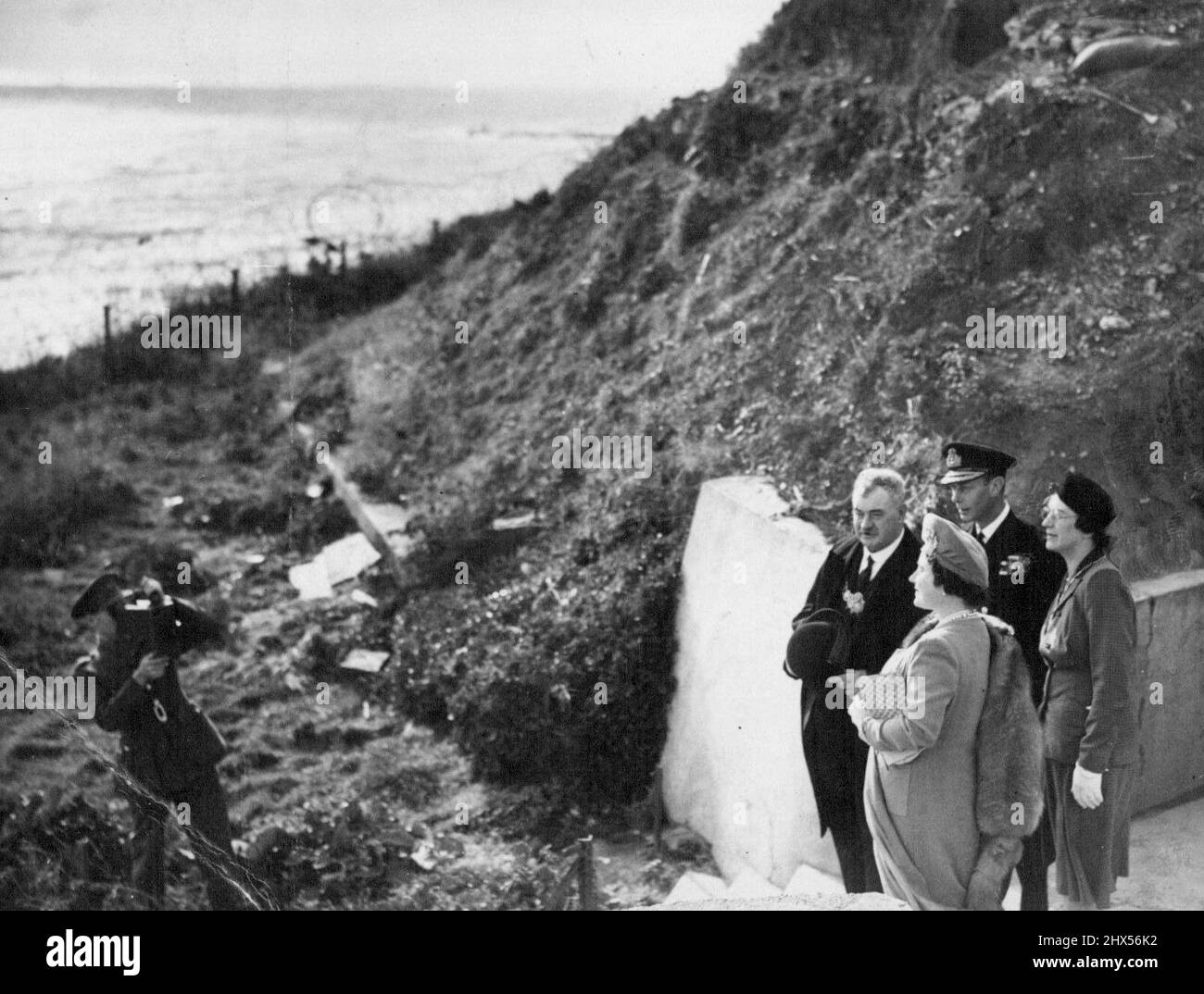 The King And Queen At 'Hellfire Corner'. Their Majesties accompanied by the Mayor of Dover, look across the Channel towards the French coast. In the scarred streets of 'liberated' ***** and Dover Folkestone, the king and Queen to-day received a great welcome. The small waiting-room of Kearsney station, just outside Dover, was the starting - point of their tour. There they met 36 Civil Defence leaders, including five Mayors and Ganger S.G. Sparkes, Southern Railway. December 04, 1944. Stock Photo