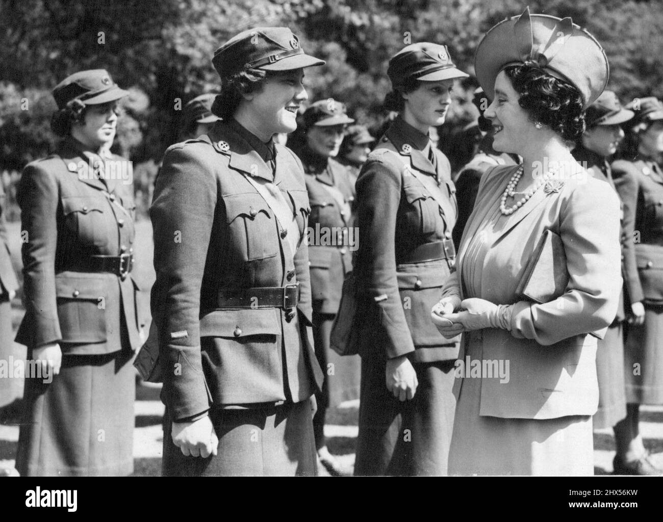 Queen Inspects Women Drivers - The Queen as she inspected the women ambulance drivers. Queen Elizabeth inspected a contingent of women members of the Mechanical Transport Corps in the gardens of Buckingham Palace, London. Three ambulances - presented by Hollywood film players were at the inspection. The Corps will take the ambulances overseas. May 21, 1940. Stock Photo