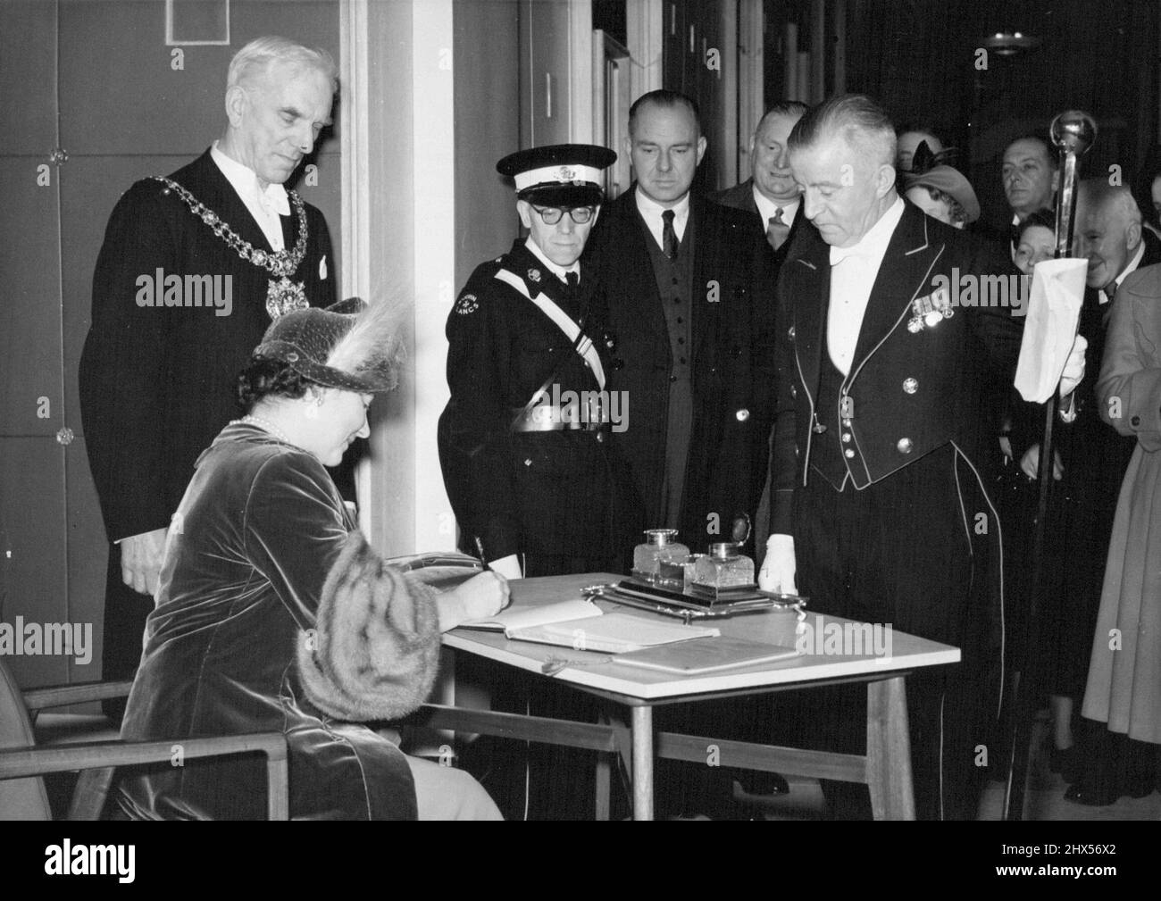 The Queen Opens Rebuilt Free Trade Hall In Manchester Her Majesty signs the book after unveiling the tablet commemorating the reconstruction and re-opening of the Manchester Free Trade Hall. Her Majesty the Queen performed the opening ceremony of the rebuilt Free Trade Hall in Manchester on Friday, November 16th, unveiling a tablet at the entrance to mark the event. November 19, 1951. (Photo by Fox Photos). Stock Photo
