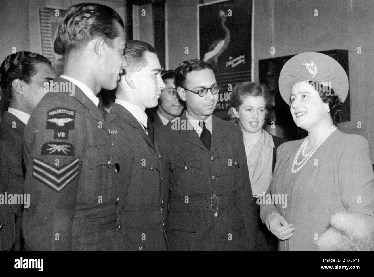 The Queen talking with a pilot officer from Fiji and on his right an air-gunner from Mauritius. H.M.The Queen this morning visited a Department of the Victoria League Colonel war services Committee where she talked to members from the colonies. November 23, 1943. Stock Photo