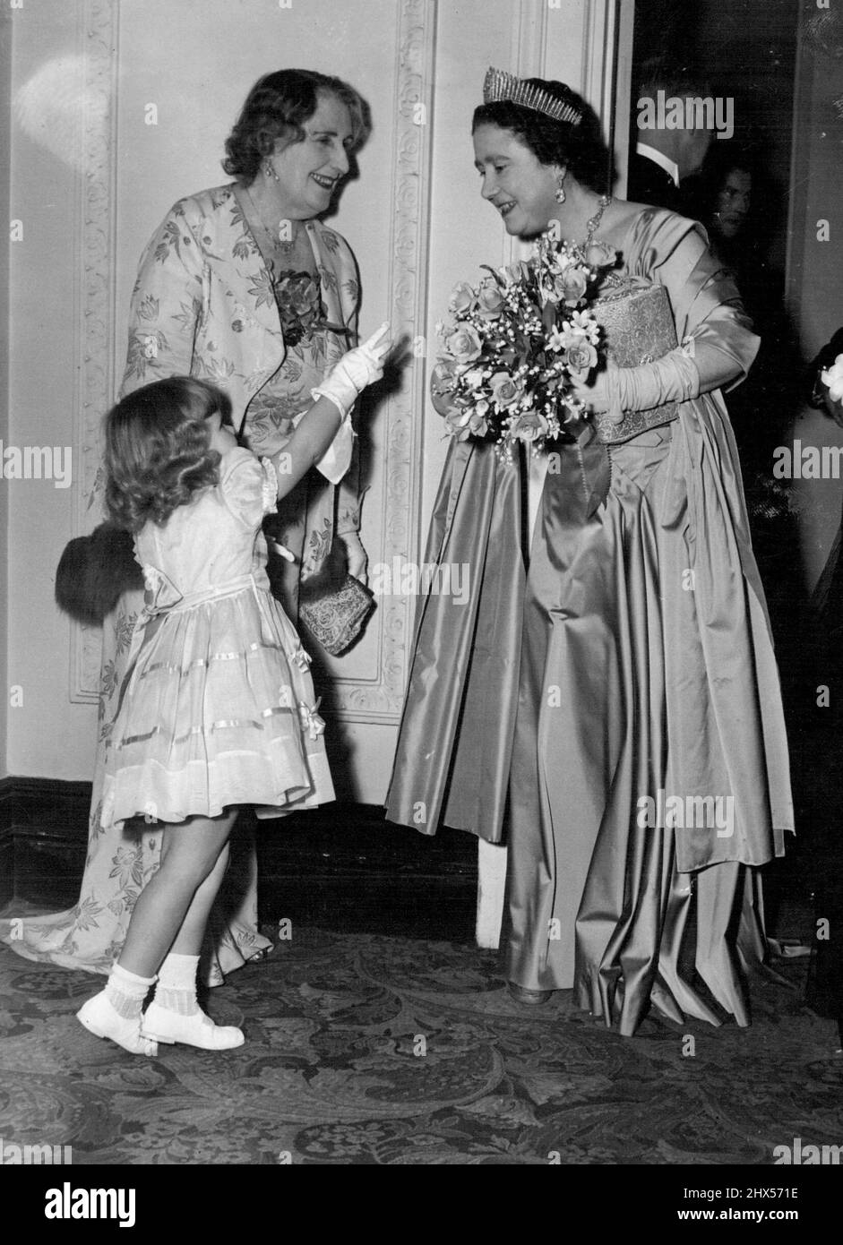 'Excuse me,' said little Sarah Osborn to the Queen Mother 'but what have you lot on your hair?' The Queen Mother replied: 'It's a tiara, my, dear.' Sarah, three-year-old daughter of Sir Danvers Osborn, had just presented a bouquet to the the Mother at a performance of 'Marie AntoiNette' at the Scala Theatre last night. December 03, 1953. (Photo by Daily Mirror). Stock Photo