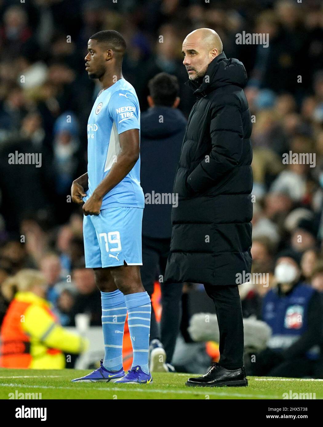 Manchester City manager Pep Guardiola (right) and Luke Mbete-Tabu during the UEFA Champions League round of sixteen second leg match at the Etihad Stadium, Manchester. Picture date: Wednesday March 9, 2022. Stock Photo