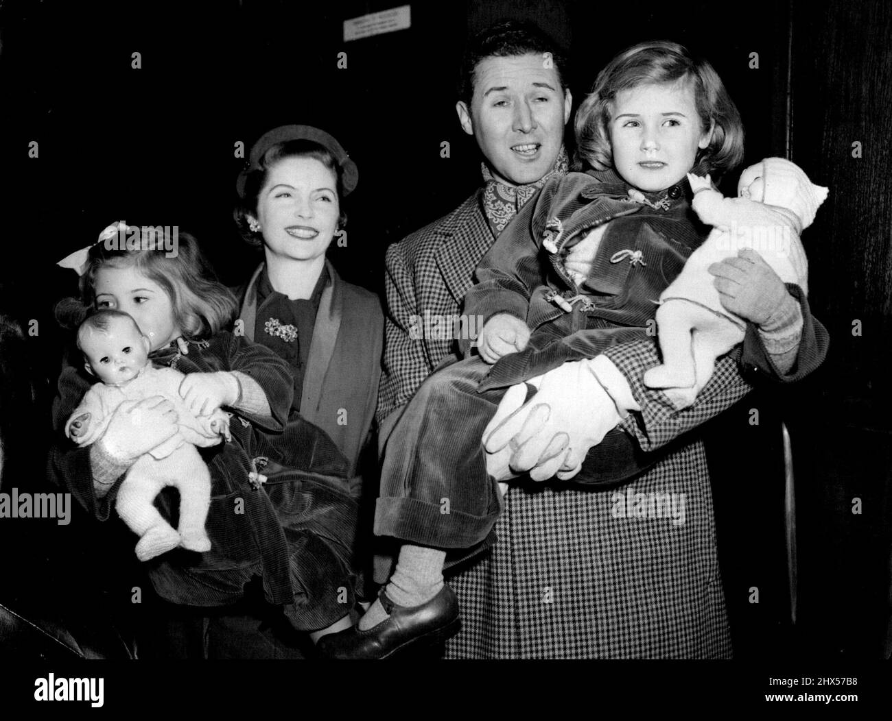 Quayle Family Off On Australasian Tour -- Mr. and Mrs. Anthony Quayle with their children on departure from Liverpool Street that Mrs. Quayle (Dorothy Hyson) is ***** Jennifer, 2½; Mr. Quayle is holding Rosanna, 4½.Members of a company of 30 artists and technicians from the Shakespeare Memorial Theatre, Stratford-on-Avon, left Liverpool Street Station, London, to-day (Tuesday) to board the New Zealand Shipping Company's liner Rangitikei at Royal Albert Dock, London. They are off on a nine-month tour of New Zealand and Australia under the leadership of Mr. Anthony Quayle (co-director with Glen Stock Photo