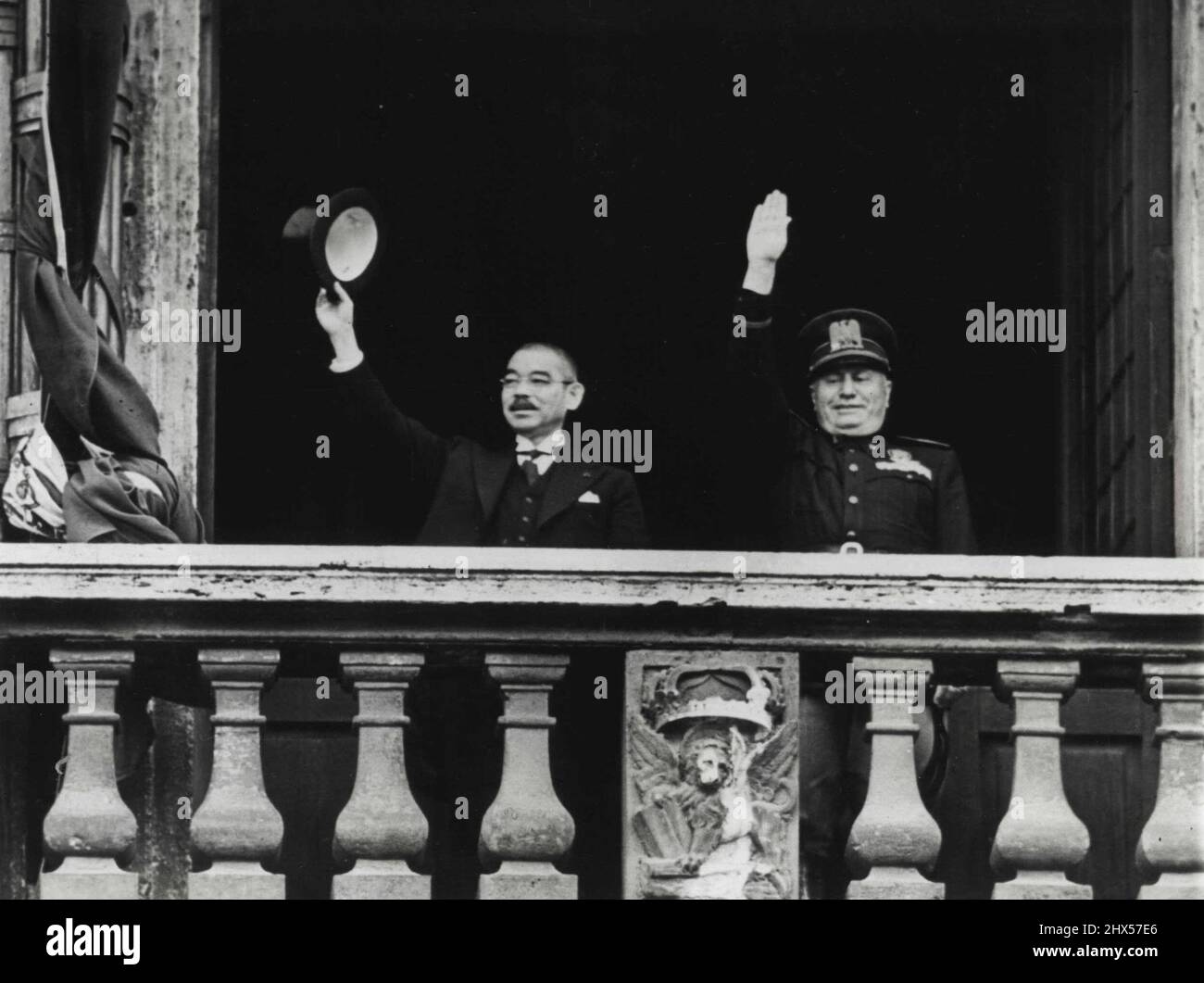 Salute From Palazzo Venezia - Japanese Foreign Minister Yosuke Matsuoka (left) waves his silk hat and premier Benito Mussolini of Italy, gives the fascist salute from balcony of the Palazzo Venezia during Matsuoka's visit to Rome on April 1. April 15, 1941. (Photo by Associated Press Photo). Stock Photo