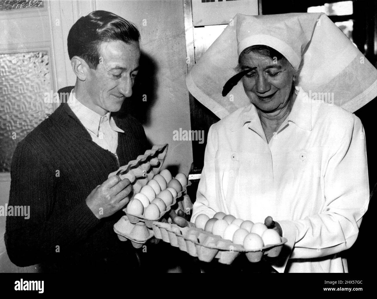 Jack Purtell Makes an Early Delivery - First in - Jockey Jack Purtell wears his winning smile as he hands over eggs to Matron E. Schafar at the Queen Victoria Hospital on his way home to Mentone from Flemington, tracks today. Purtell hopes that all sportsmen will aid the hospital's egg appeal. September 28, 1954. Stock Photo