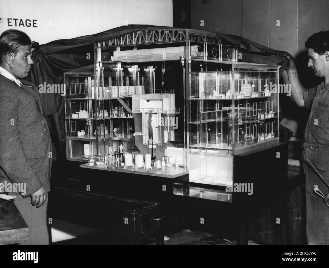 Soviet's Atom Exhibit. Russia Engineers and Swiss Workmen in Geneva unveil a plastic glass reproduction of a heavy water research reactor 'operating somewhere in central Russia', to be shown at the exhibition to be held in connexion with the international conference on the peaceful uses of Atomic energy, which opens in the Palais De Nations, August 8. August 15, 1955. (Photo by Associated Press Photo). Stock Photo