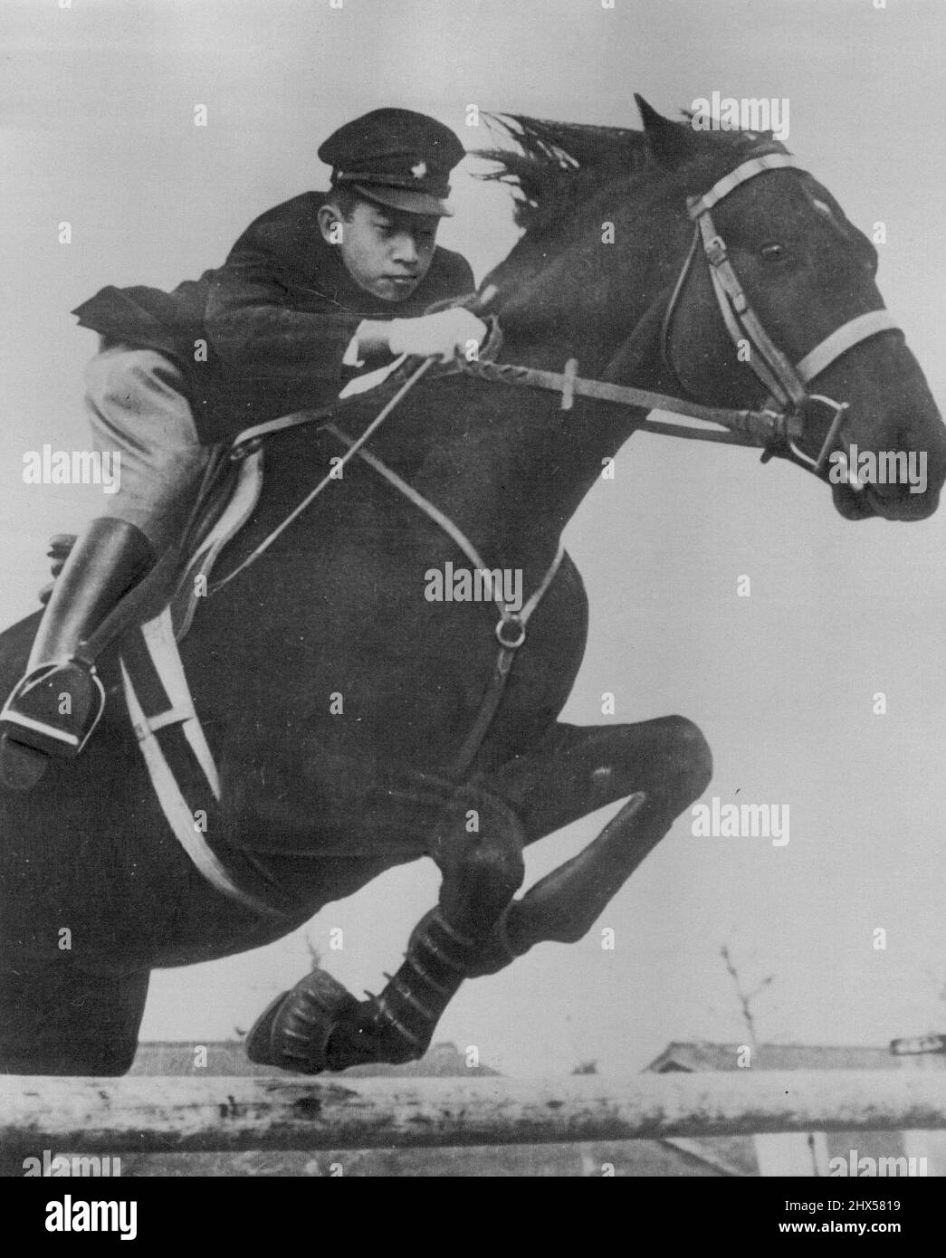 Crown Prince Akihito, 18-year-old son of Japanese Emperor Hirohito, gives a display of horsemanship as he rides his pet horse 'Wakazakura' over an obstacle in Tokyo. This picture was taken by photographer of the Japanese Imperial household. December 31, 1951. (Photo by AP Wirephoto). Stock Photo