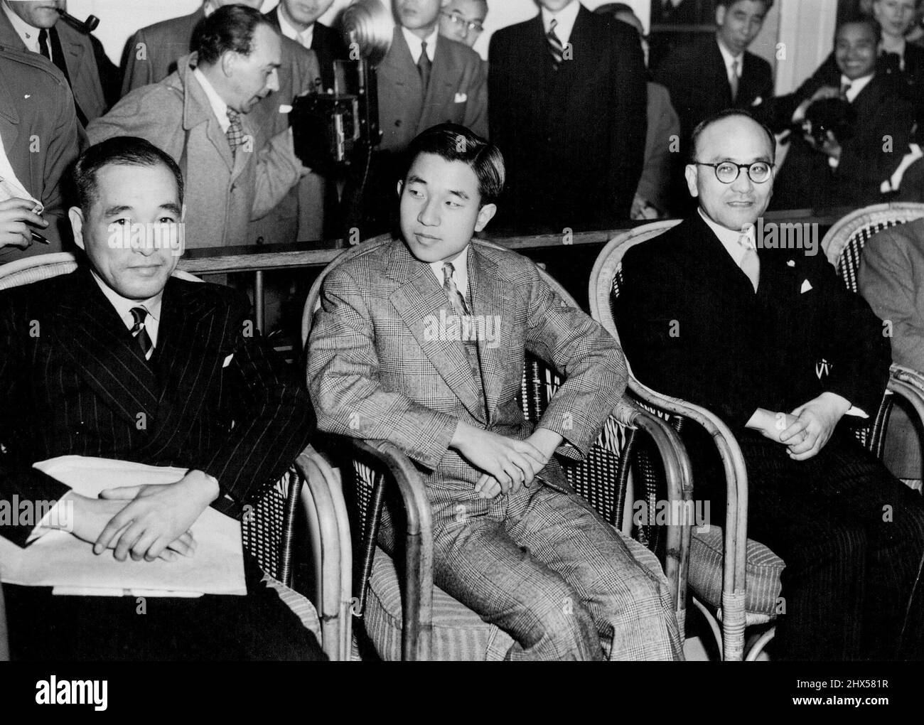 Crown Prince Of Japan Arrives -- Seen (centre) on his arrival here aboard the liner Queen Elizabeth is the Crown Prince of Japan, Prince Akihito, 19, who has come to England to represent Emperor Hirohito at the Coronation. He will be received by the Queen at Buckingham Palace on May 5. At left is the Japanese Ambassador Mr. Matsumoto. April 28, 1953. (Photo by Planet News Ltd.). Stock Photo