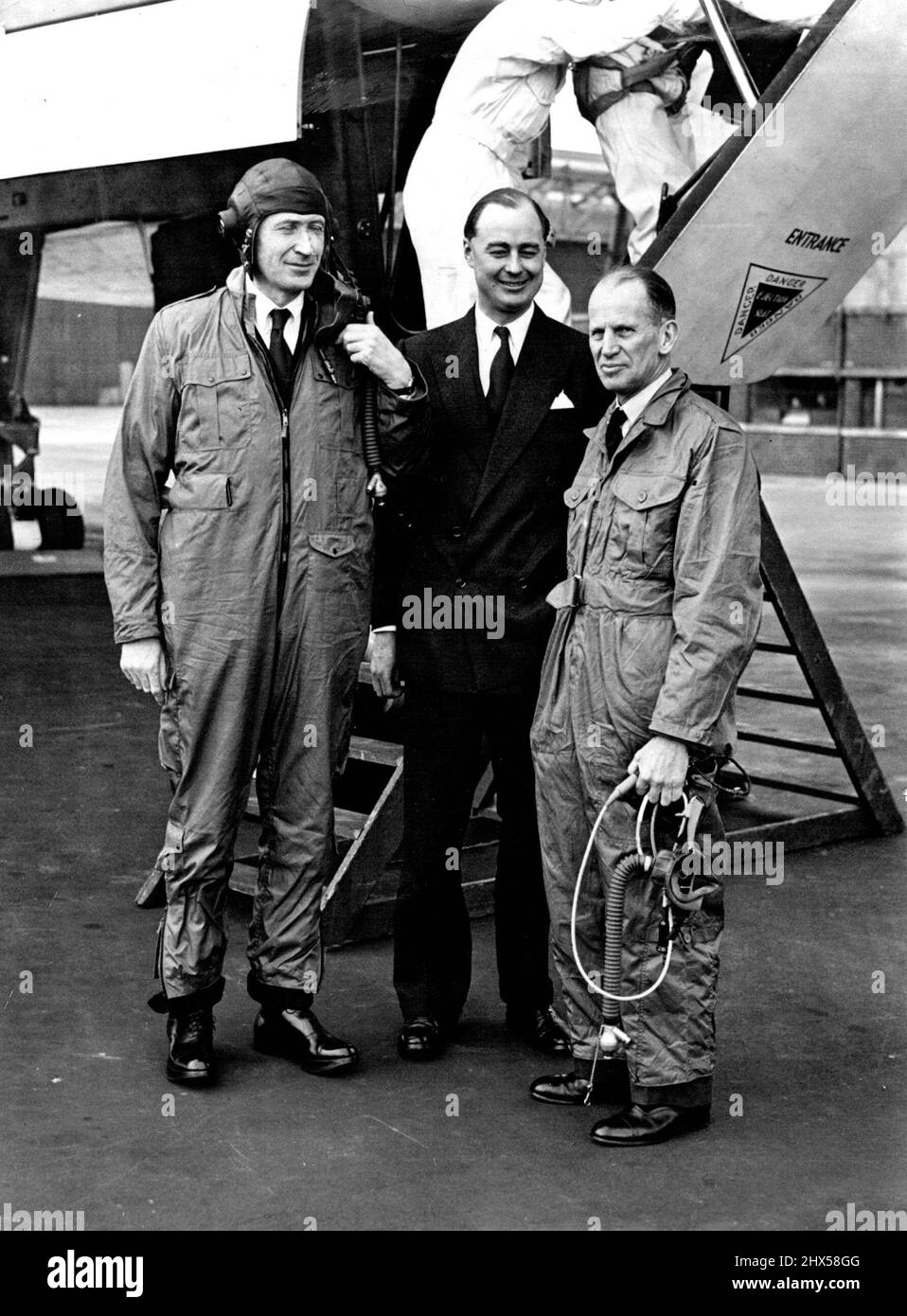Minister Tries Out Vulcan Jet Bomber -- The Minister of Supply, Mr. Duncan Sandys (left) is pictured here with Avro's Superintendent of Flying, Wing Commander Roland Falk (Centre) and Air Chief Marshal Sir John W. Baker at Woodford Airport, near Manchester, today (Saturday) after a flight in one of Britain's latest jet bombers, the Delta-wing Avro Vulcan. The Minister took over the flight, over the Isle of Wight and back by way of Holyhead, In which the plane is believed to have reached more than 500 mph.It was made during his visit to the works of A.V.Roe and Co., Ltd., the aircraft's builder Stock Photo