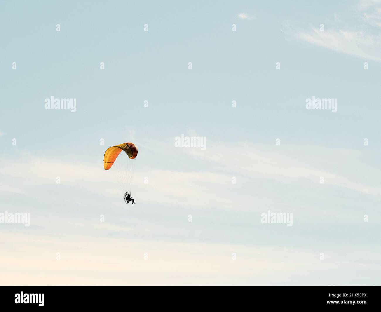 Powered or motorized hang glider, gliding or soaring high above Mobile Bay, Alabama, USA. Stock Photo