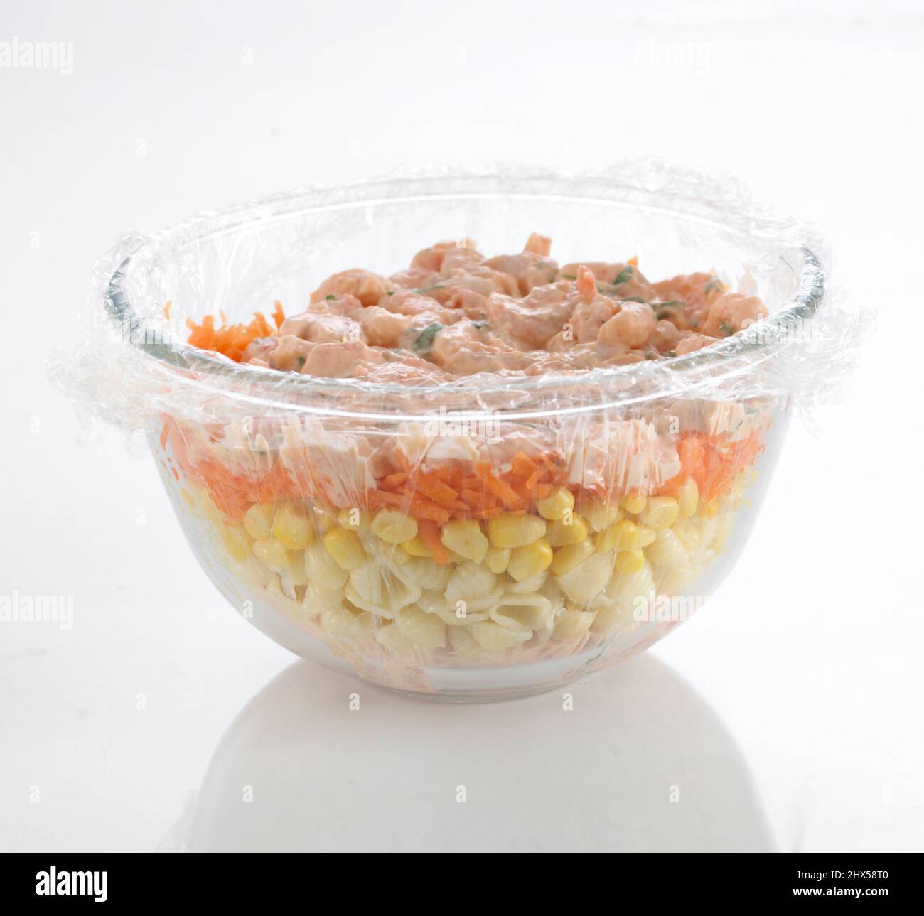 Prawns in thousand island dressing on top of layers of grated red cheese, sweetcorn, and pasta