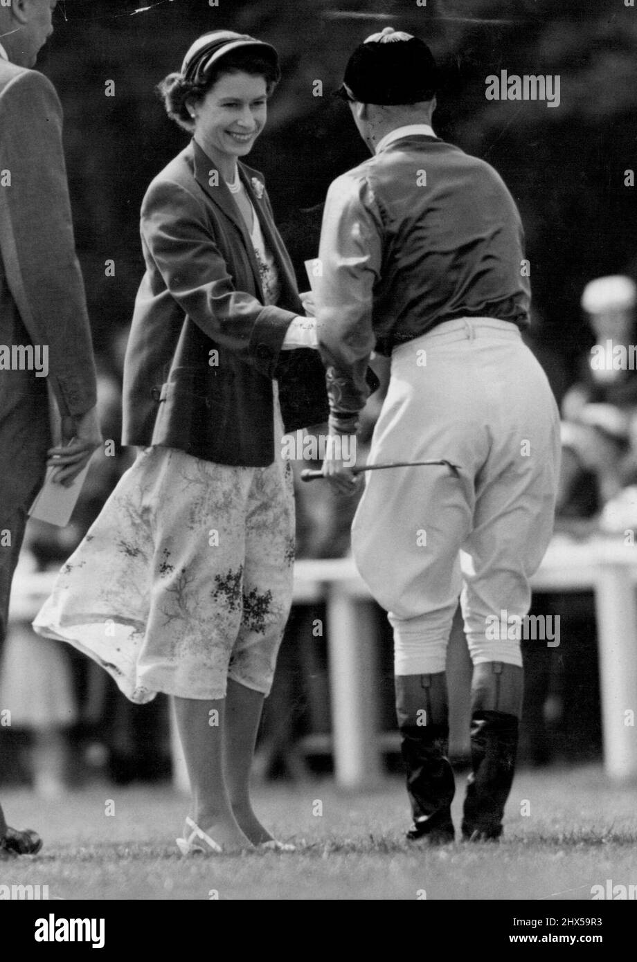 The Queen At Epsom Today -- Smiling radiantly, H.M. The Queen is seen wishing her jockey W.H. Carr 'Good Luck' prior to the Oaks Stake at Epsom today, in which her filly 'Angel Bright' was a runner. In today's bright sunshine Her Majesty wore a floral summer dress, with short jacket of emerald green and small matching hat. June 4, 1954. (Photo by Fox Photos). Stock Photo