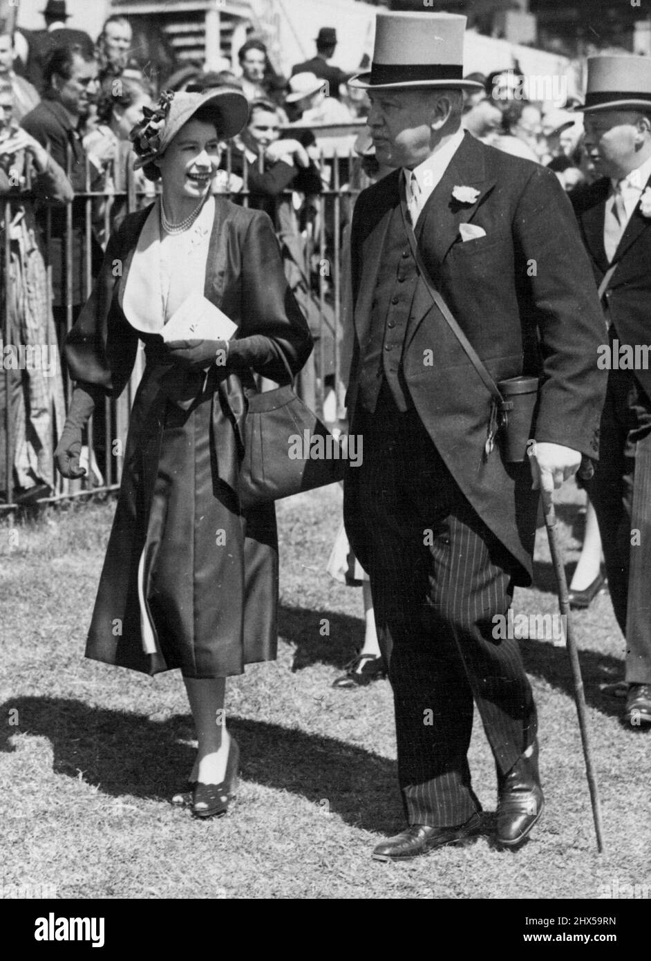 Princess At The Oaks - It Was Ladies Day -- The Oaks Day at Epsom, Surrey, races has always been Ladies Day. Today the weather was kind so that there were many charming fashions. Princess Elizabeth, seen in this picture, wore a lilac straw ***** hat and a summery outfit - a plum coloured gross-grain coat with the new 'melon' sleeves which reached just below her ***** elbows and fashionable low revers faced with lilac satin. Also in the picture are Lord Rosebery and, behind him, the Duke of Norfolk. June 1, 1951. (Photo by Paul Popper Ltd.). Stock Photo