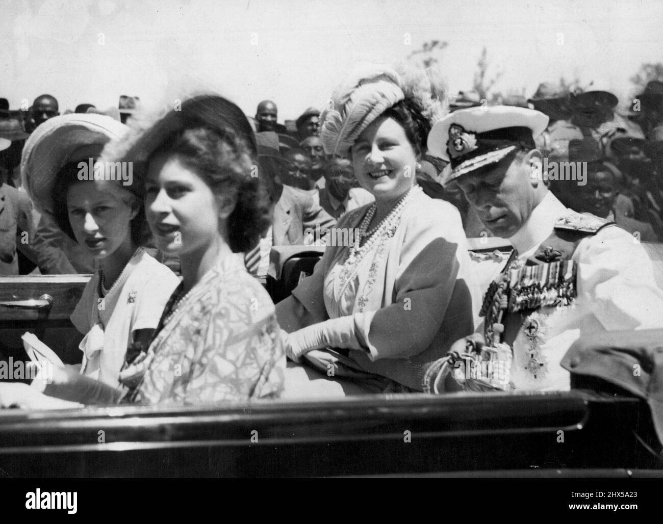 The King and Queen, Princess Margaret Rose (extreme left) and Princess Elizabeth arriving in the Royal car for the ceremonies that attended their visit to Transkei. A great host of nations, headed by their Chiefs, congregated at Umtata, Transkei, form all the Transkeian territories to pay homage to the Royal family, when they visited the native Capital, during their tour of South Africa. The King, who was wearing tropical Naval uniform, with garter ribbon and sword, presented medals to many of the Paramount chiefs, and it was here that for the first time the Royal Family heard the famous Royal Stock Photo