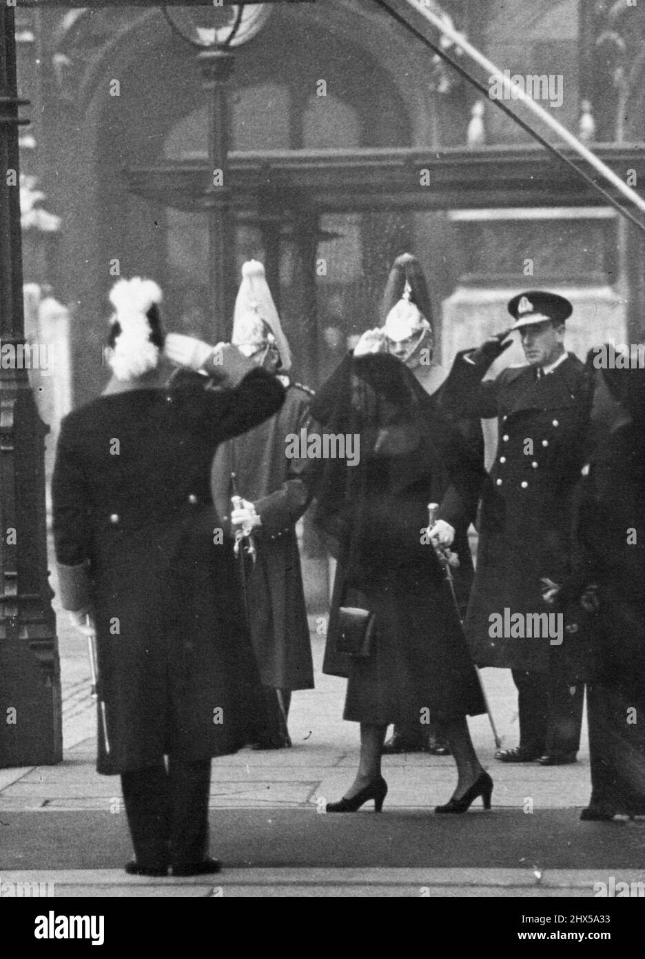 Royal Funeral: Queens at Westminster Hall - The Queen and the Queen Mother walking to their carriage at Westminster Hall. Saluting on right is seen. Earl Mount Batten(in naval uniform). Sorrowing London bade farewell to King George VI to-day (Friday). When his funeral cortege passed from Westminster Hall to Paddington Station, where the coffin was entrained for Windsor. February 15, 1952. (Photo by Reuterphoto). Stock Photo