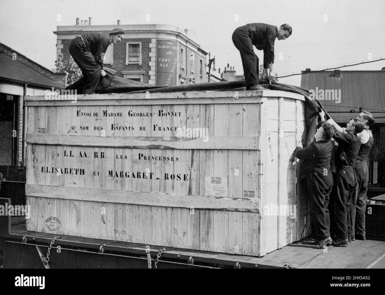 Princesses' Dolls Arrive With 20 Trunks Taking the tarpauling sheet off  ****** large packing-case on its arrival at the ***** Arms Goods Station,  London, S.E. to-day. France and Marianne, the dolls presented