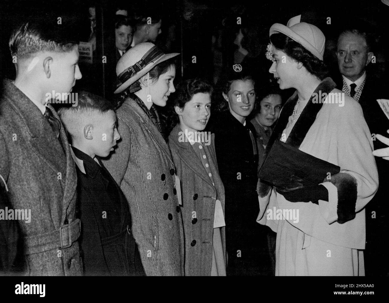 Princess Elizabeth, on the eve of her 23rd birthday, with the children at Victoria to-day. Fifty Childers, 25 boys and 25 girls chosen from bomb Victims and orphans in London, Manchester, Birmingham and Plymouth, holiday, they are to spend four weeks in Lucerne, Switzerland at the expense of the hoteliers and City Council of Lucerne to celebrate the birth of Prince Charles. Princess Elizabeth was at Victoria Station to see them off. She spoke to many of them and also to French boys and girls who were returning to their homes round Lille after a heliday in England. April 20, 1949. Stock Photo