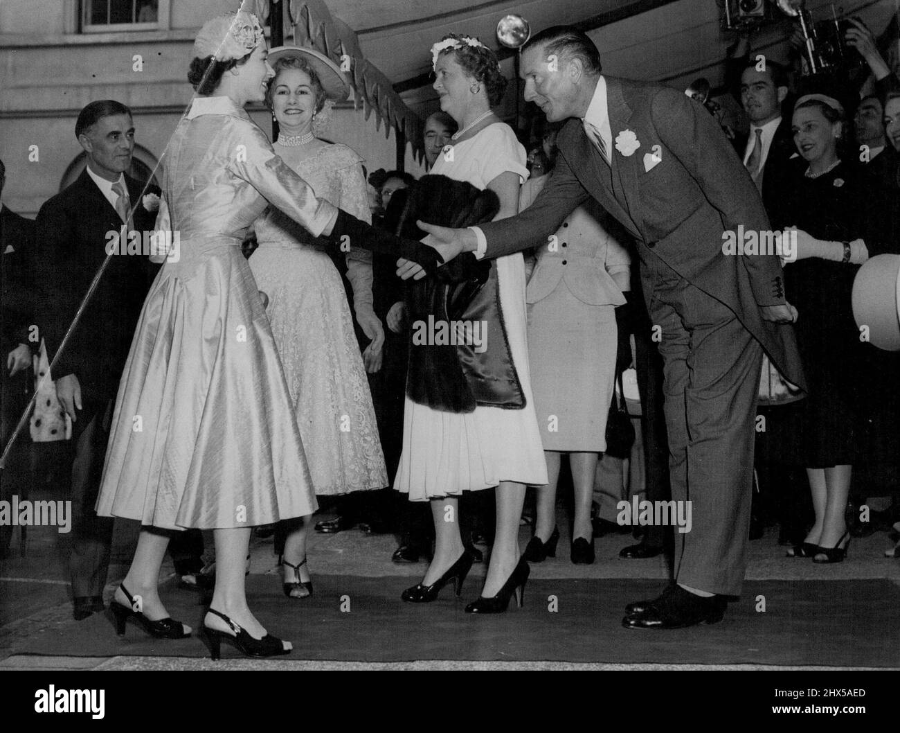 Queen Attends Friend's Wedding Reception -- The Queen is received on arrival at Hutchinson House, Stratford Palace, London, to-day (Wednesday) to attend the wedding reception of her friend, Lady Mary Baillie - Hamilton and Mr. Adrian Bailey, who were married at St. James' Spanish Place, W. Lady Mary was a maid of honour to the Queen at the Coronation. She is the daughter of the Earl and Countess of Haddington. July 21, 1954. (Photo by Reuterphoto). Stock Photo