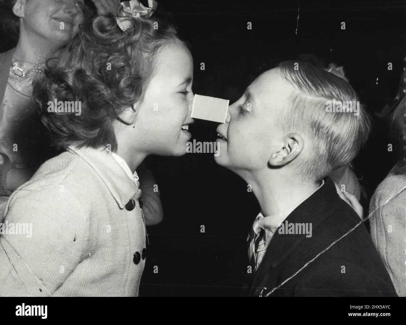 National Institute for Deaf Children Party at Y.W.C.A. Great Russel Street. Part Game of exchange the match-box, Jacqueline Farrow and Brian Gordon. Jacqueline Farrow and Brian Gordon nosed ***** into this party game with a matchbox Melbourne party for Deaf, Dumb and Blind Institute children. January 03, 1954. Stock Photo