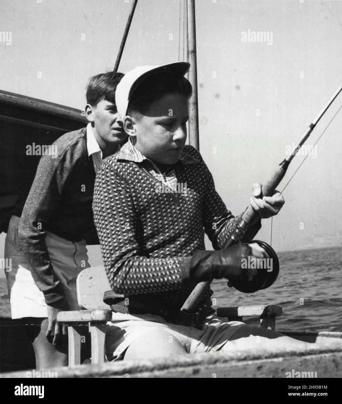 In training for Australia's first game fishing contest for schools, Hadyn Daly, 13, Kogarah High (above), plays a fish off Sydney Heads. Two-boy teams from 27 metropolitan schools and one team from Gosford will take part in the contest, which will be decided off the Heads next Saturday. Trophies worth more than £350 will be awarded, and 28 big game launches will take the boys through the Heads at 8 am. There is one section for the biggest shark, one for marlin and a third for light game. Sydney Game Fishing Association, the Shark Anglers' Club and the Rod Fishers Club are co-operating. Stock Photo