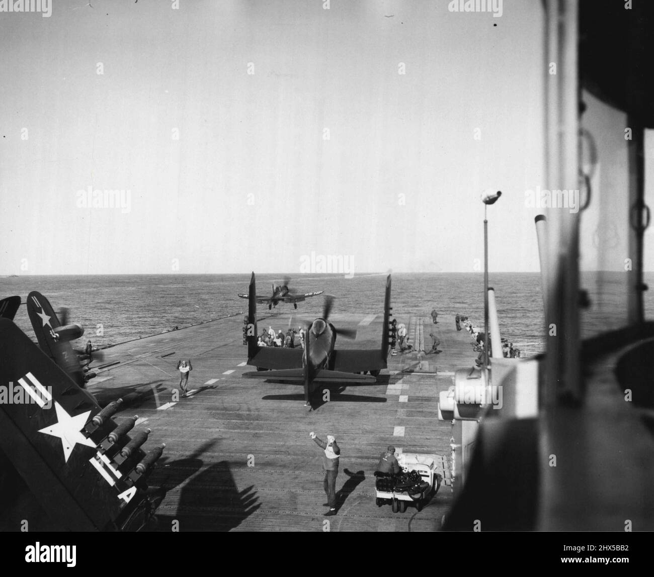 Eurled Against The Communists -- Powerful catapults flush with the dock of fast carrier USS Boxer fling Navy Corsair fighters, armed to the teeth, against enemy troops, bridges and supplies, back of the lines in North Korea. Ranging the north-east coast of the battered peninsula at will, planes from the Boxer and other carriers of Fast Carrier Task force 77 support the ground fighting by constant day and night attacks on Key rail and highway transportation lines. Aerial photos prove heavy trains and trucks are virtually at a standstill in Northeast Korea as the enemy strains to supply his troo Stock Photo