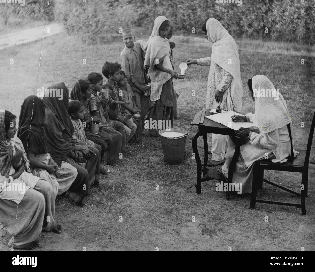 Refugees scenes 1947, India. Walton Refugee Camp, Lahore. Milk being distributed among children. January 21, 1948. Stock Photo