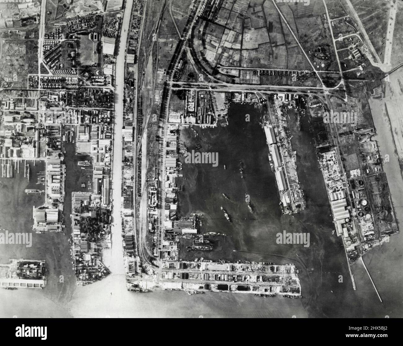 Hargets for Allied bombers in the Netherlands East Indies: Soerabaja ***** in Java photographed in a low sweep over that important Dutch ***** now occupied by the Japanese. Tandjoeng Perak harbor (centre) ***** its excellent docking facilities. Tandjoeng Perak airdrome Japanese ***** right). Mas River (left center). Naval base now utilized by ***** left). October 31, 1943. (Photo by U.S. Air Force). Stock Photo