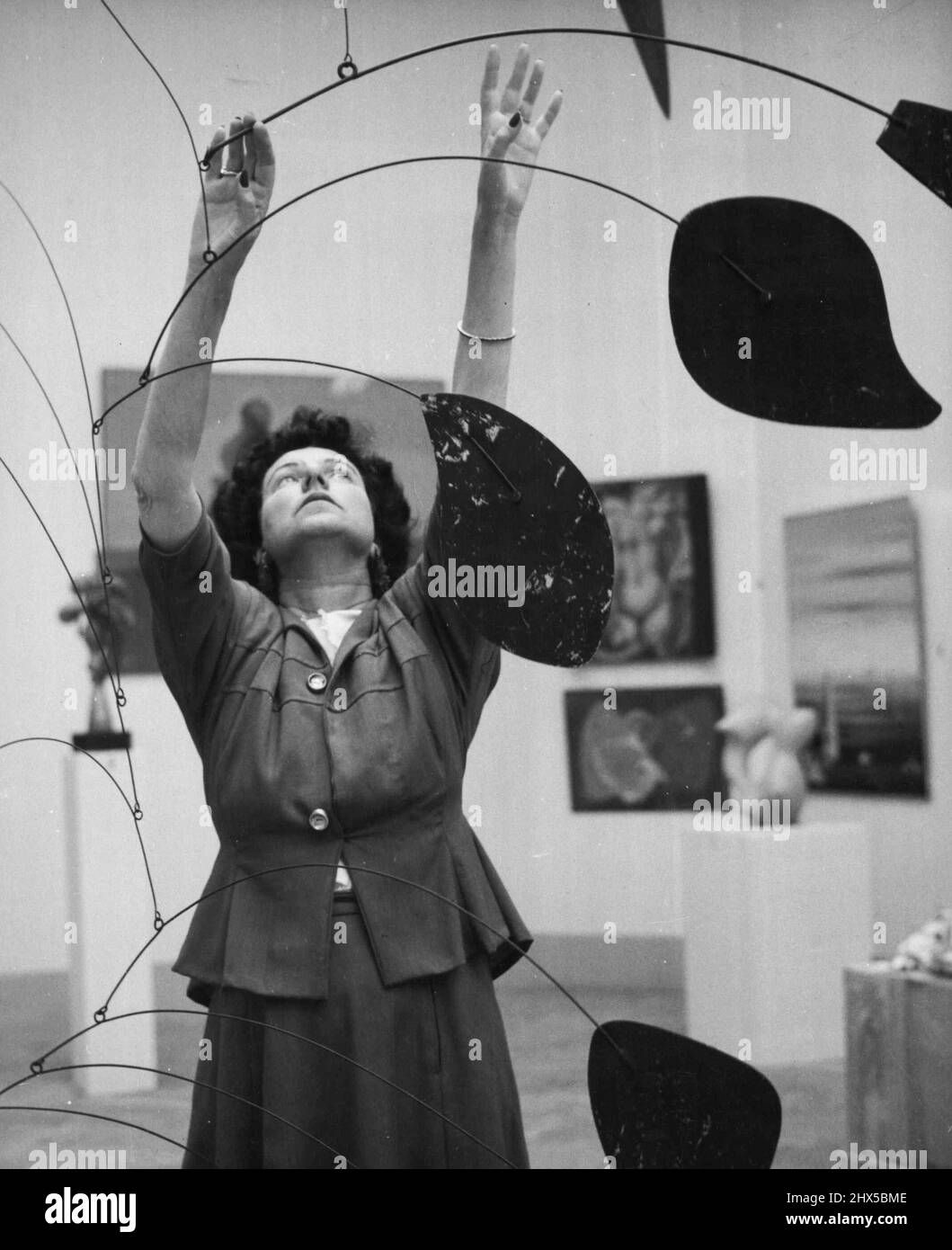 Peggy Guggenheim In Venice At the International Art Exhibition in Venice, Peggy takes ***** personally to put every one of her 'pieces' on its right place. Here she is with a fine sculpture by Alexander Calder. January 11, 1949. (Photo by Interfoto). Stock Photo