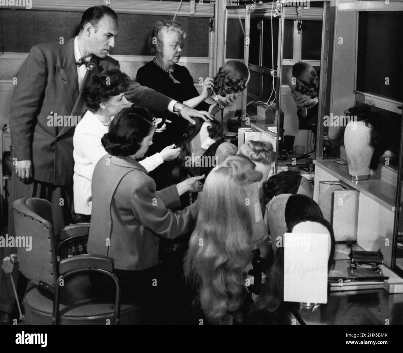 Sidney Guilaroff supervises the dressing of wigs prior to the day designated for testing make-up and costume. Metro-Goldwyn-Mayer's Technicolor production of 'Little Women' has a cast including such favorites as June Allyson, Peter Lawford, Elizabeth Taylor, Margaret O'Brien, Janet Leigh, Mary Aster, Sir C. Aubrey Smith, Lucile Watson, Elizabeth Patterson, Leon Ames and Richard Stapley. It is directed and produced by Mervyn LeRoy. May 26, 1950. Stock Photo